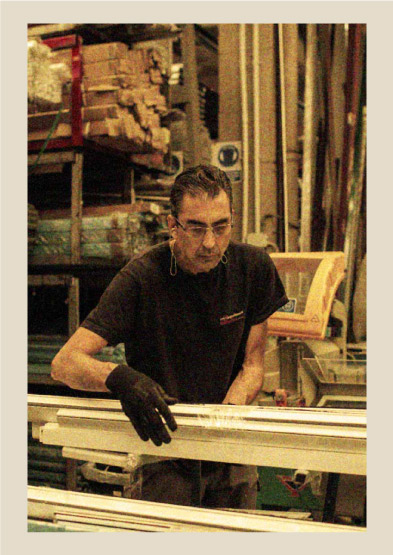 Trabajador con camiseta mosquiterasbaratas.com fabricando mosquiteras